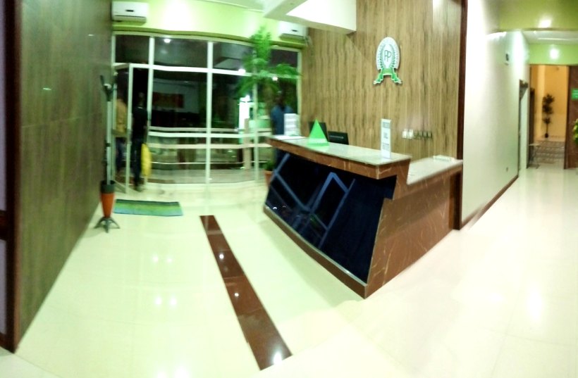 Le comptoir de réception dans le hall d’entrée, sous le logo de la polyclinique